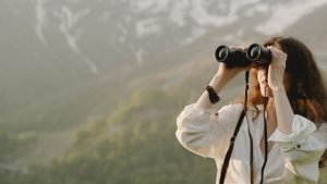 mujer con prismáticos que encuentra clientes en linea